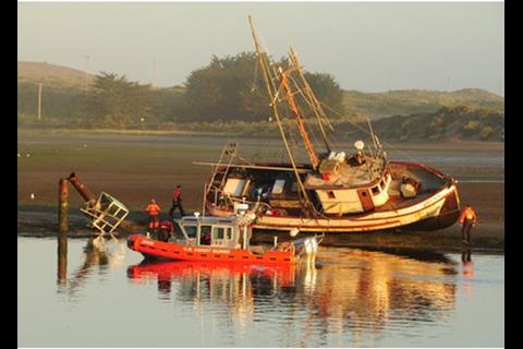 USCG crew inspecting a grounded fishing boat at Bodega Bay, California